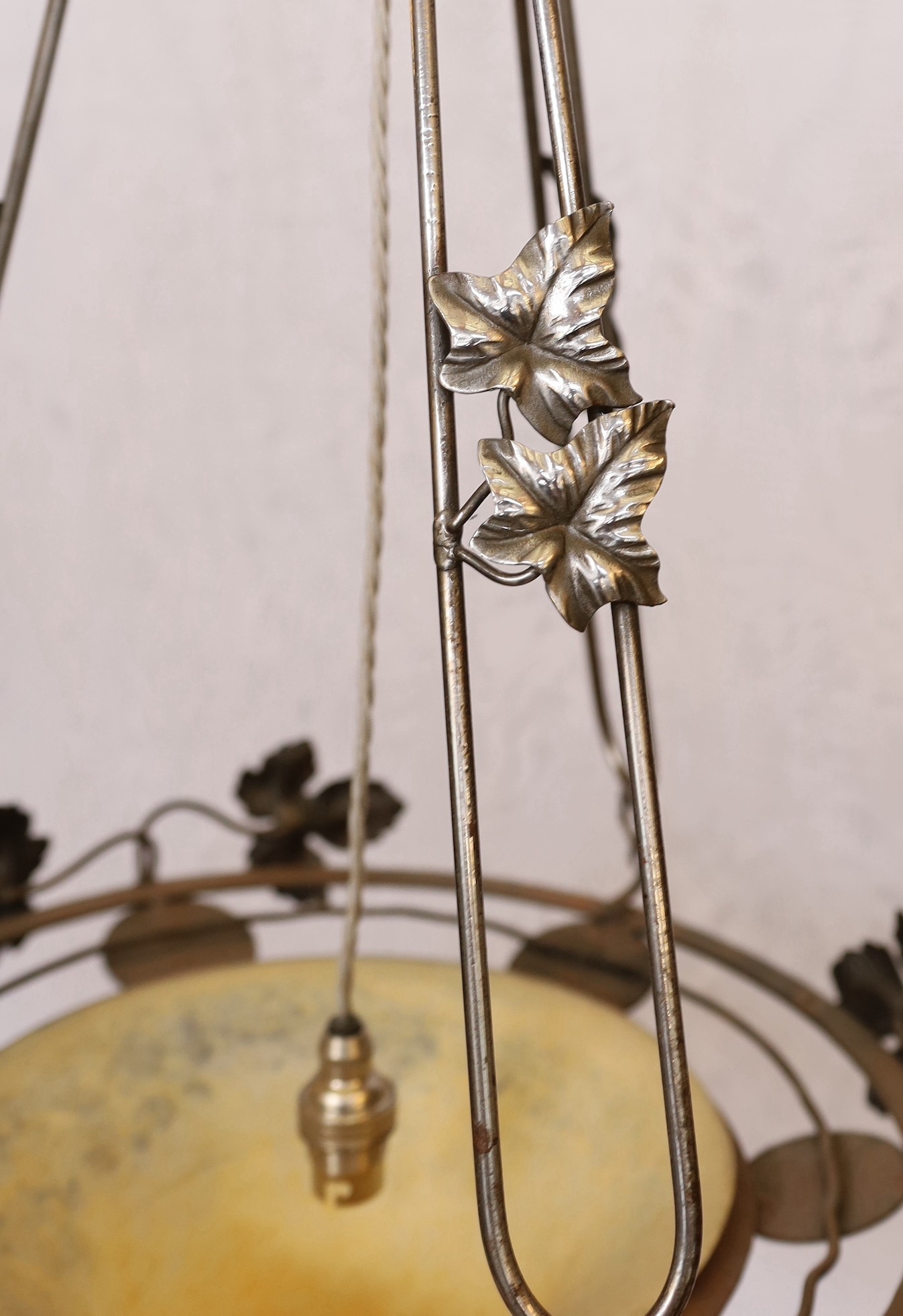 A 1920's-30's French polished wrought iron and marbled glass light fitting decorated with foliate motifs, drop 90cm, width 40cm